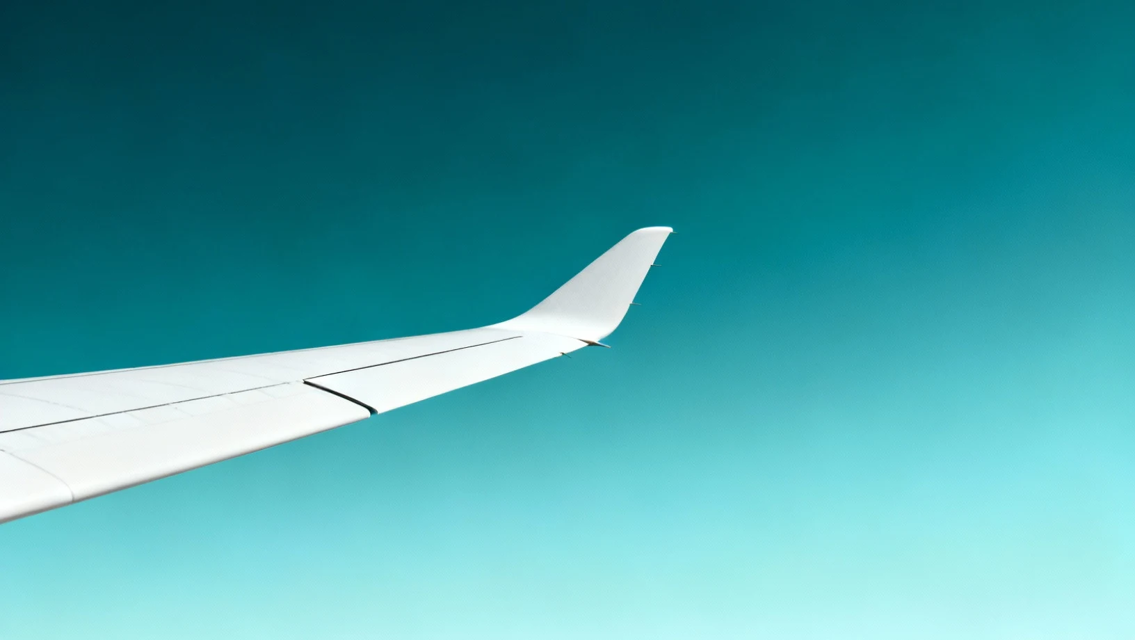 Aile de planeur dans un ciel cyan